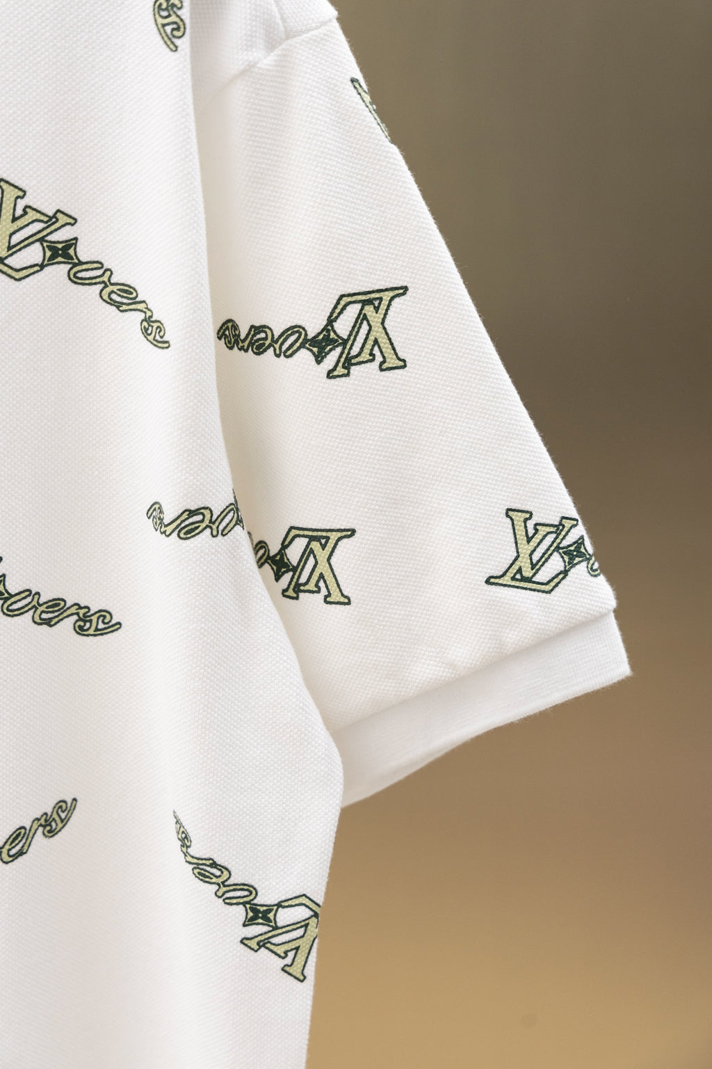 White polo shirt sleeve and shoulder with Louis Vuitton-style logo print