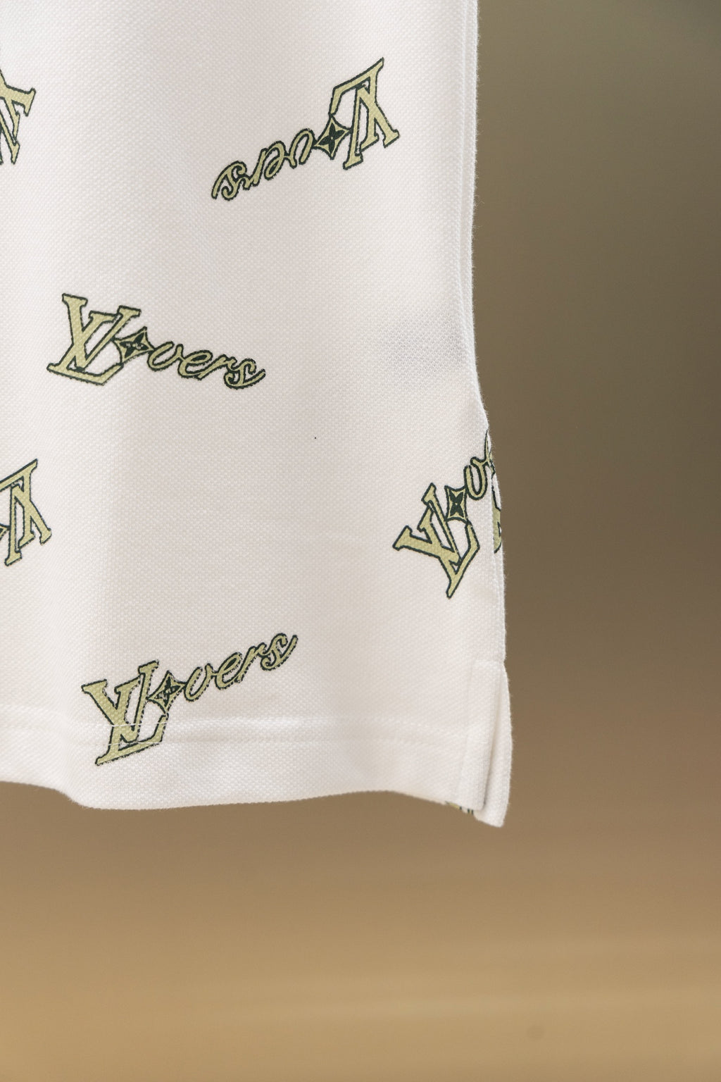 White polo shirt side hem with Louis Vuitton-style logo print