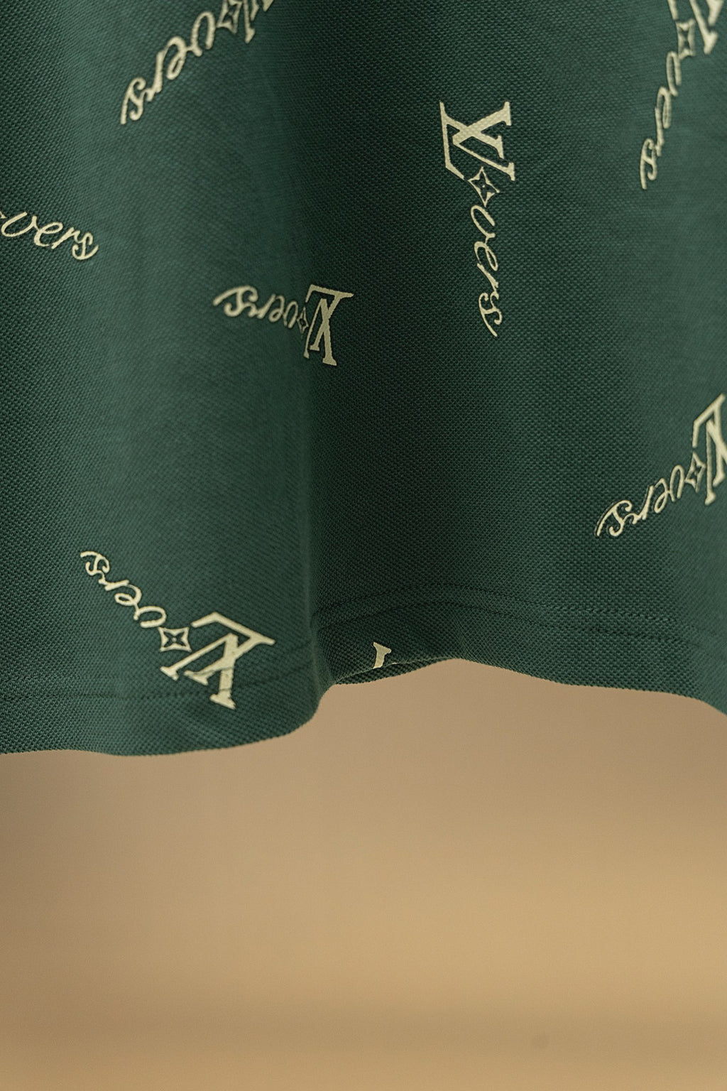 Louis Vuitton polo shirt hem in dark green with repeating logo pattern