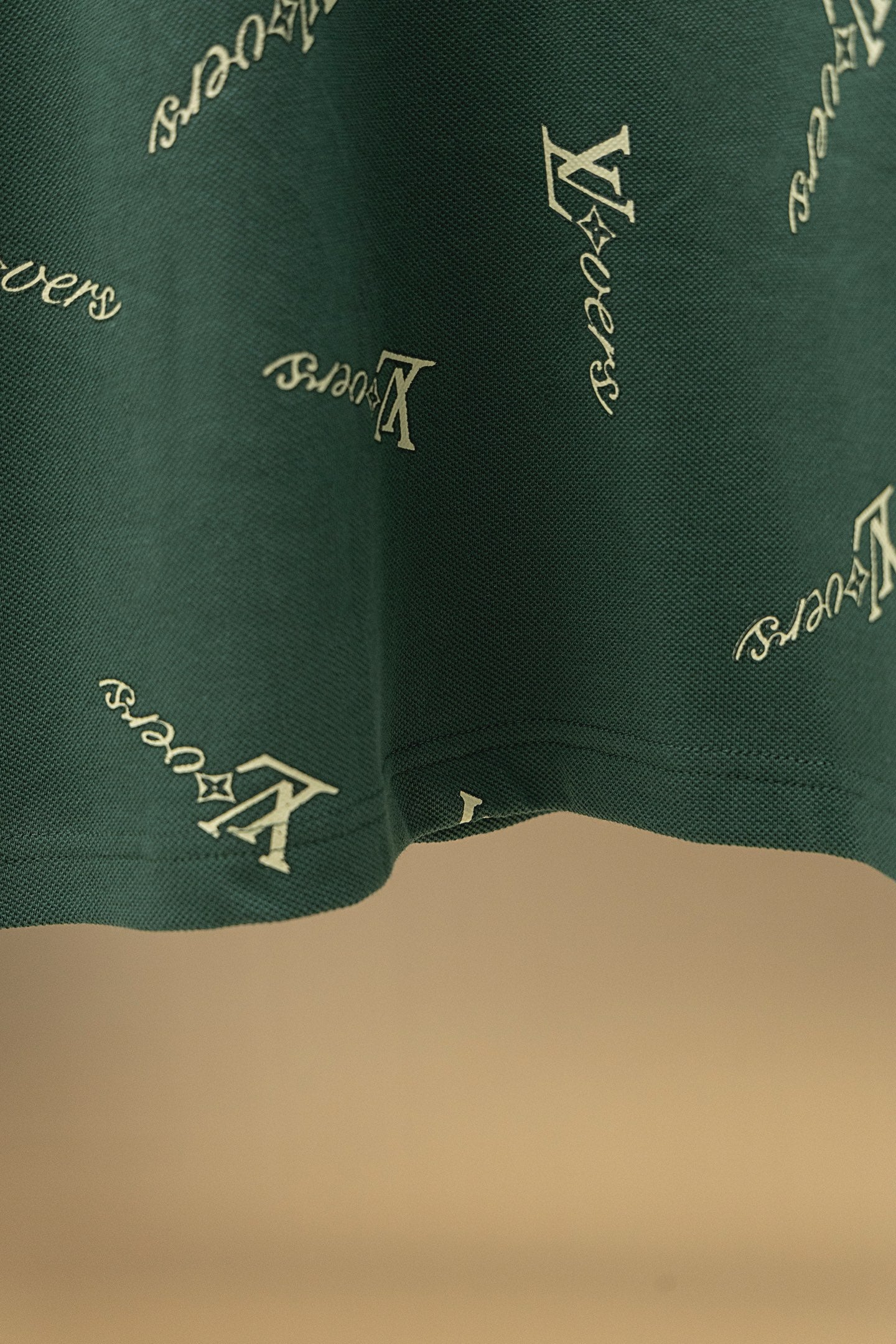 Louis Vuitton polo shirt hem in dark green with repeating logo pattern