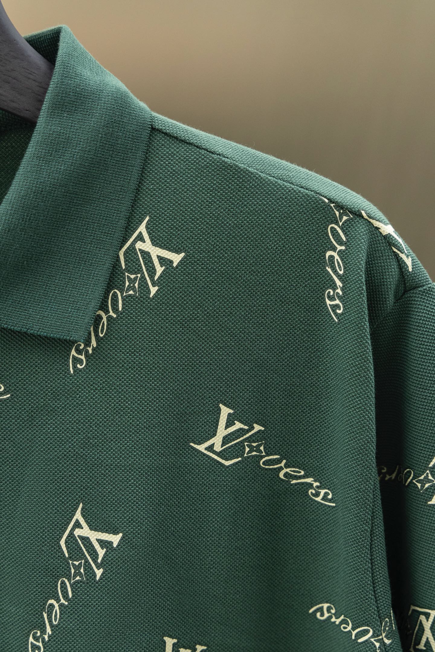 Louis Vuitton polo shoulder and sleeve in dark green with repeating logo pattern