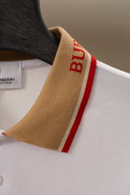 Burberry polo shirt sleeve detail: tan cuff with red “B” stripe