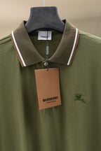 Burberry polo shirt front view in olive green with tag, buttons, and striped collar
