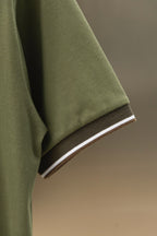 Burberry polo shirt sleeve cuff with striped trim on olive green fabric