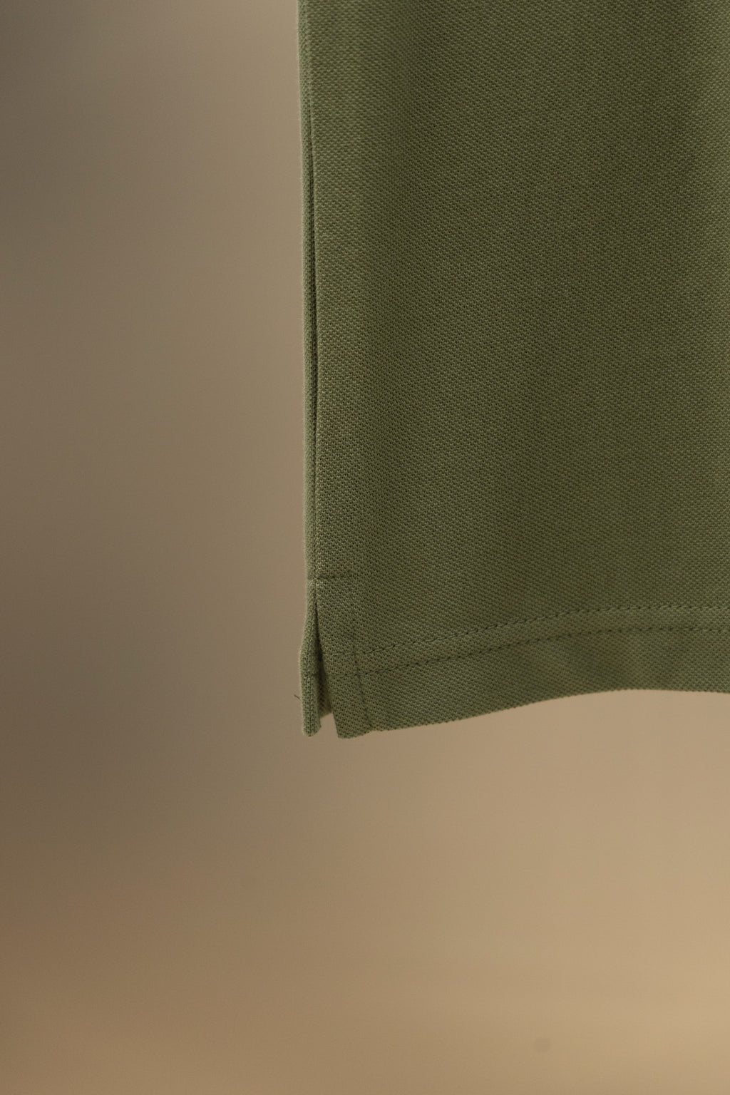 Burberry polo shirt hem on olive green fabric