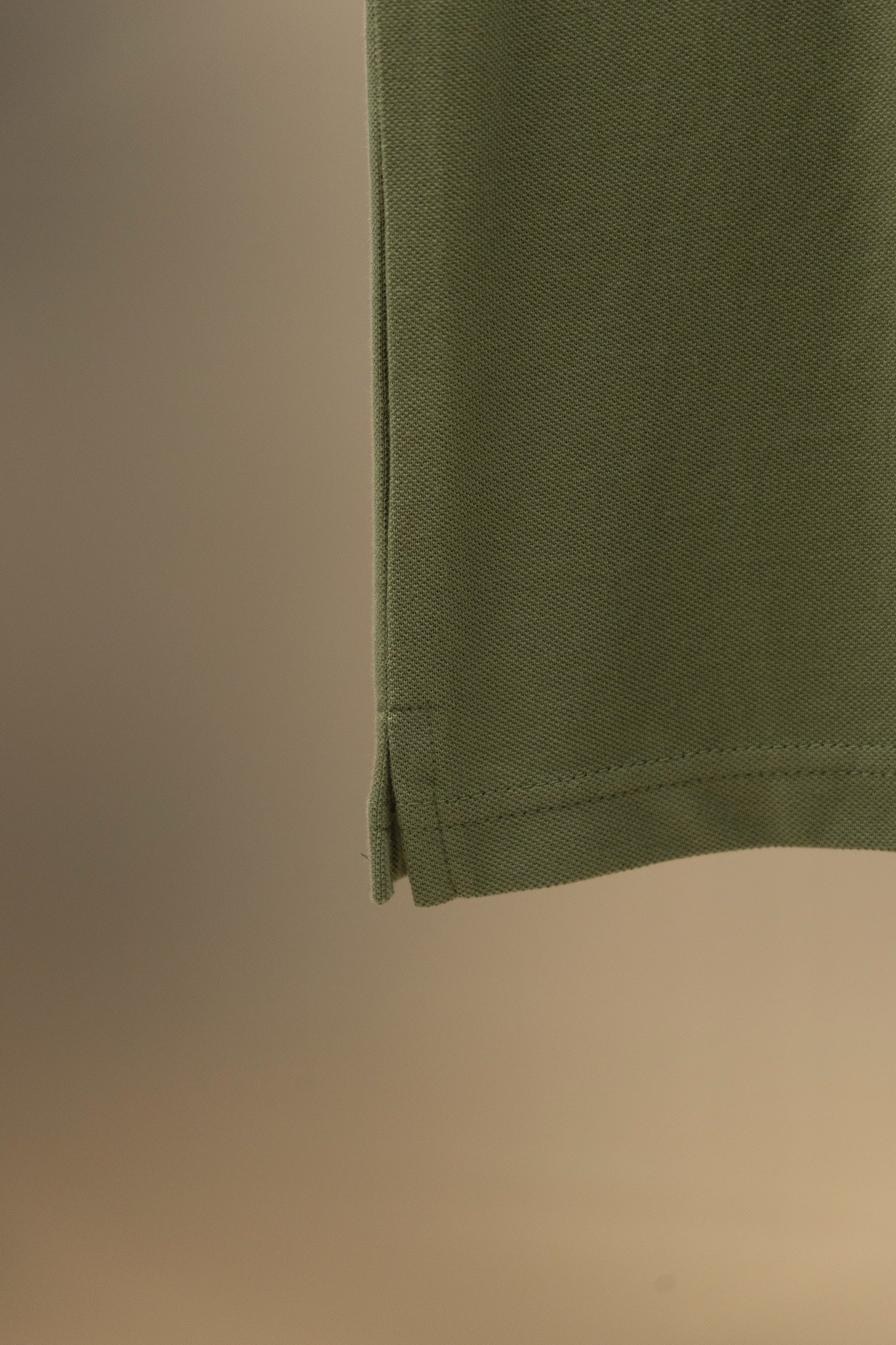 Burberry polo shirt hem on olive green fabric