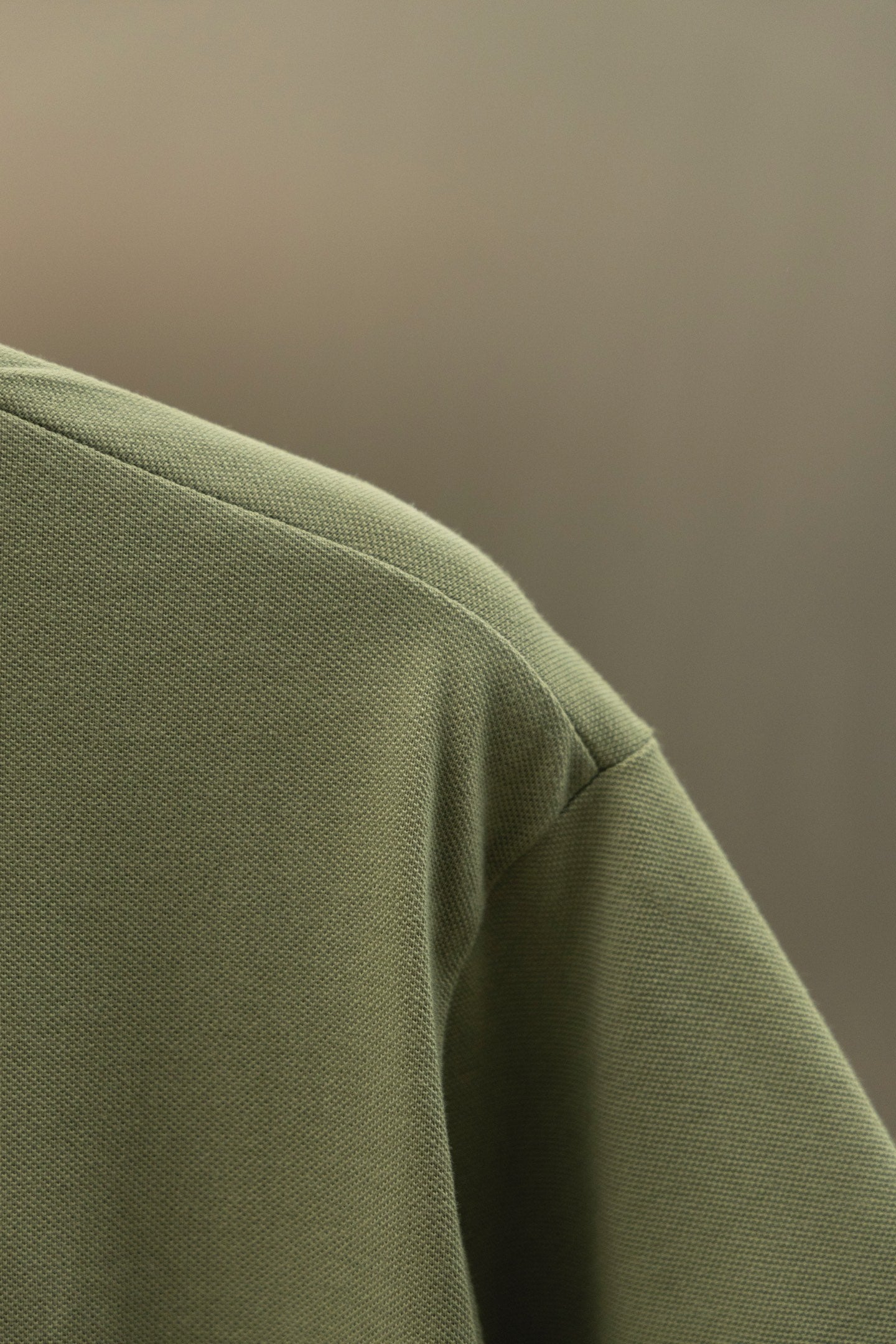 Burberry polo shirt fabric close-up in olive green with side seam detail