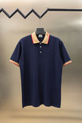 Navy polo shirt with beige and red striped collar and short sleeves, button placket