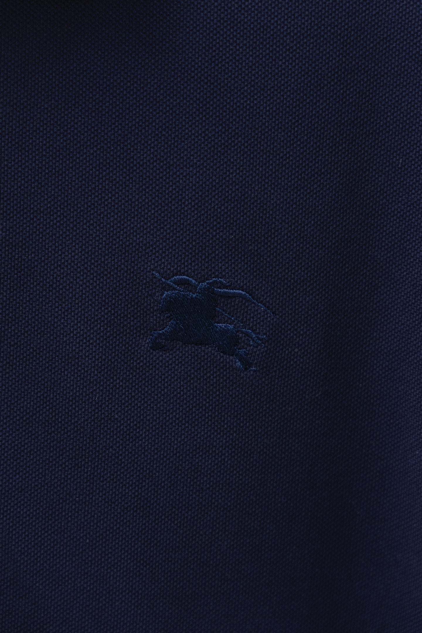 Navy polo shirt chest logo embroidery detail