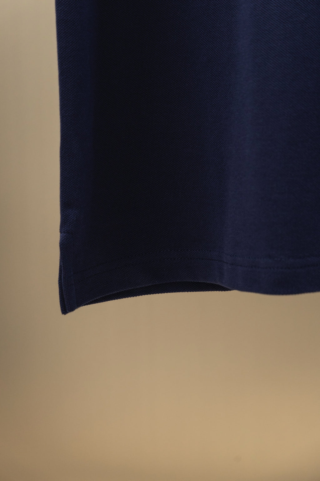 Navy polo shirt hem view with clean straight bottom edge
