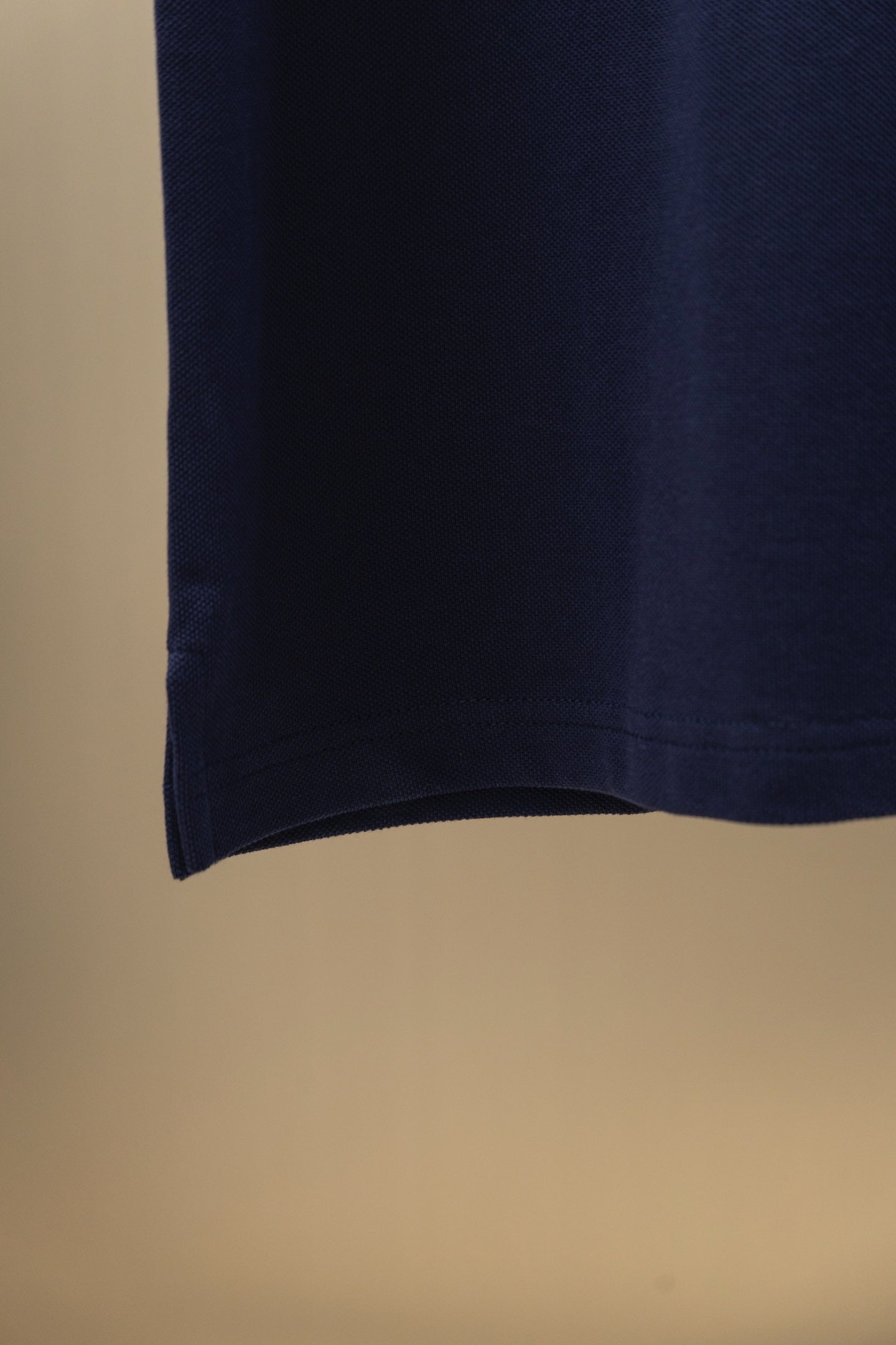 Navy polo shirt hem view with clean straight bottom edge
