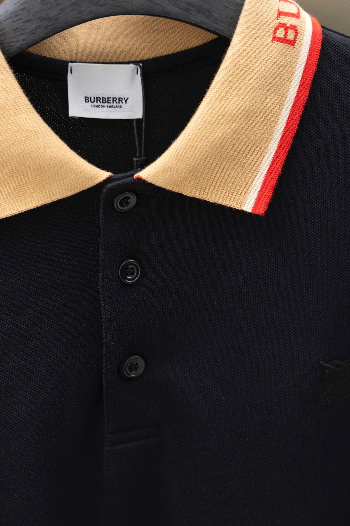 Burberry polo shirt with dark button placket and striped collar trim