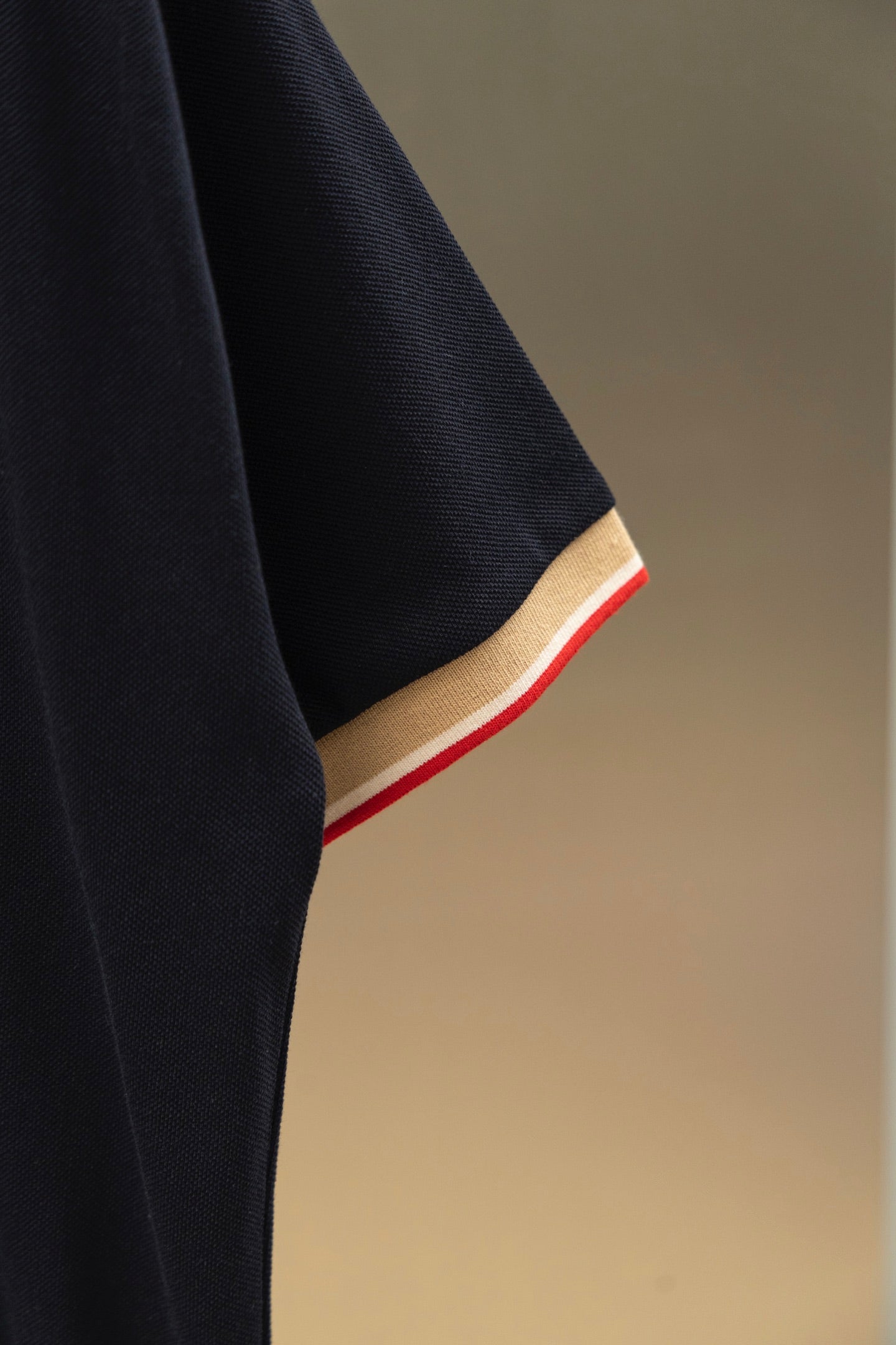 Burberry navy polo shirt sleeve with beige cuff band and red edge trim