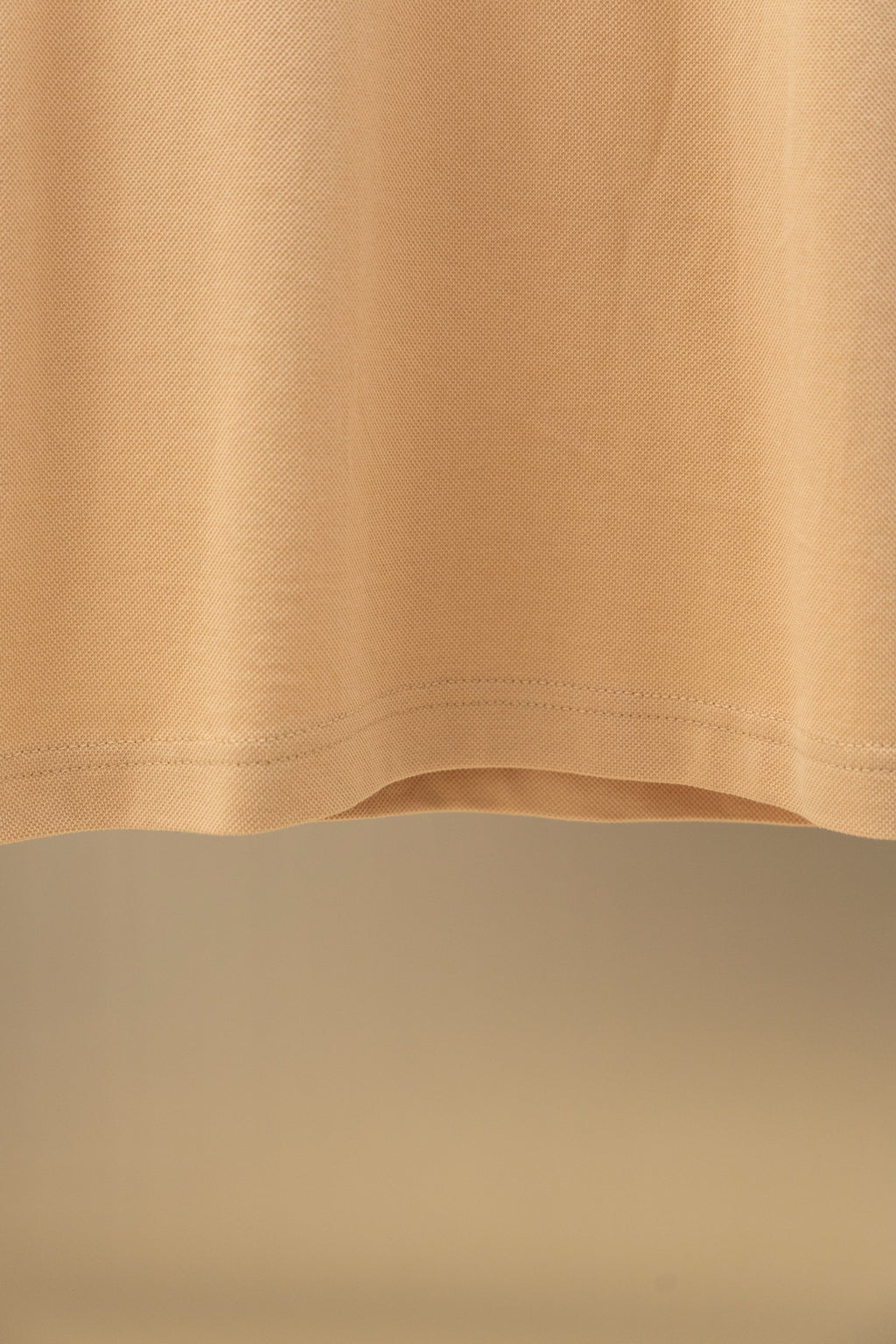 Tan polo shirt hem and side seam detail