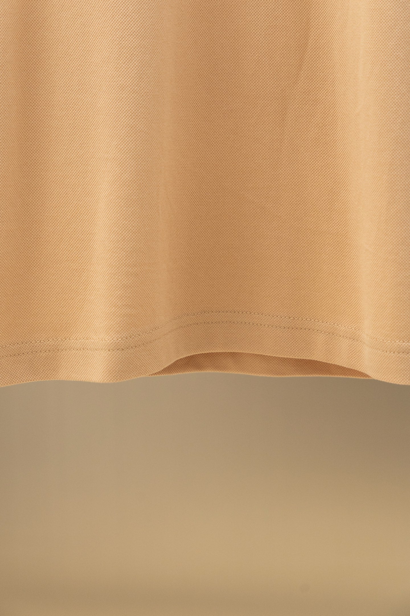 Tan polo shirt hem and side seam detail