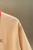 Light beige polo shirt side close-up with small chest logo detail