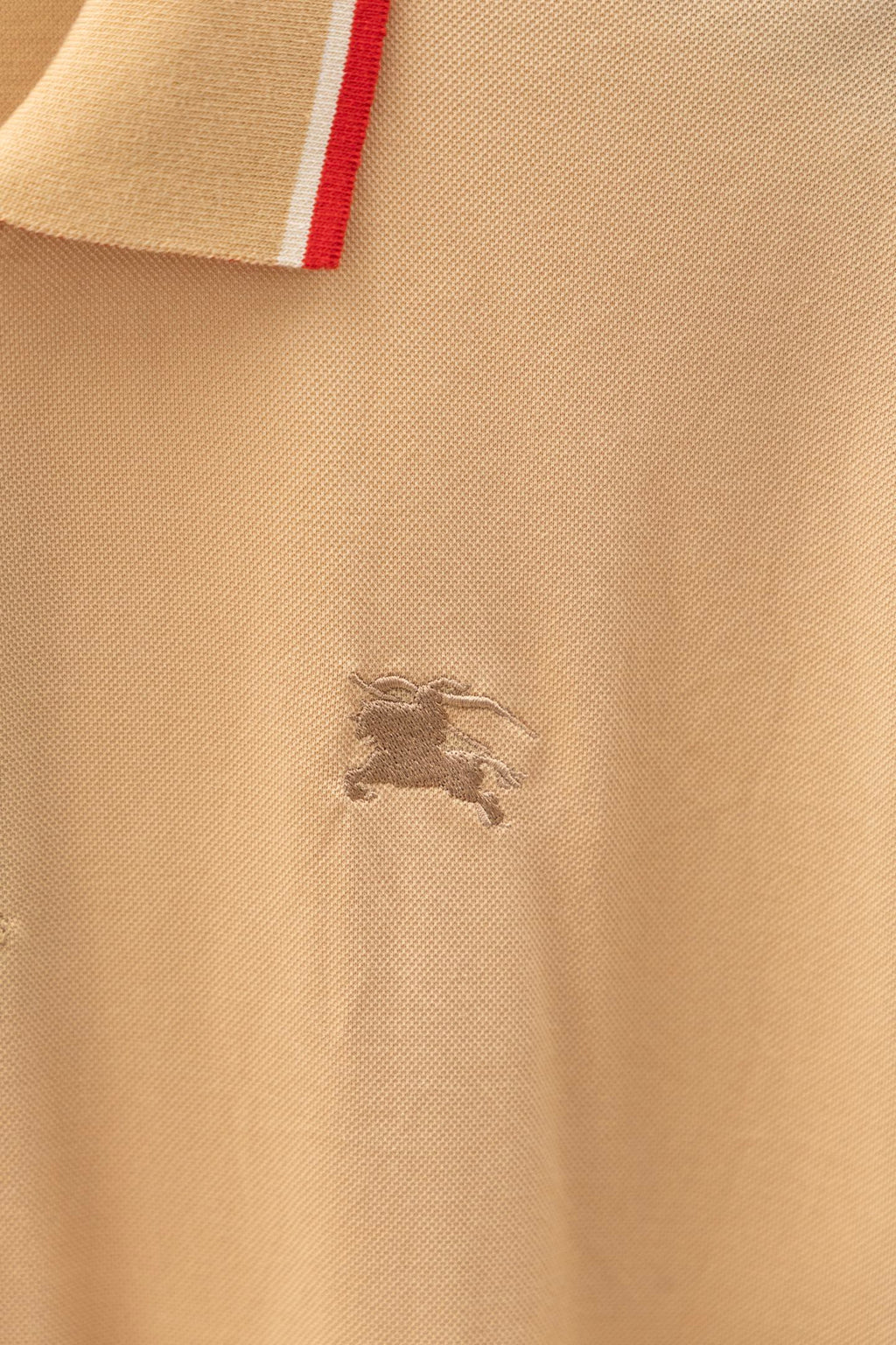 Light beige polo shirt with small embroidered horse logo on the chest