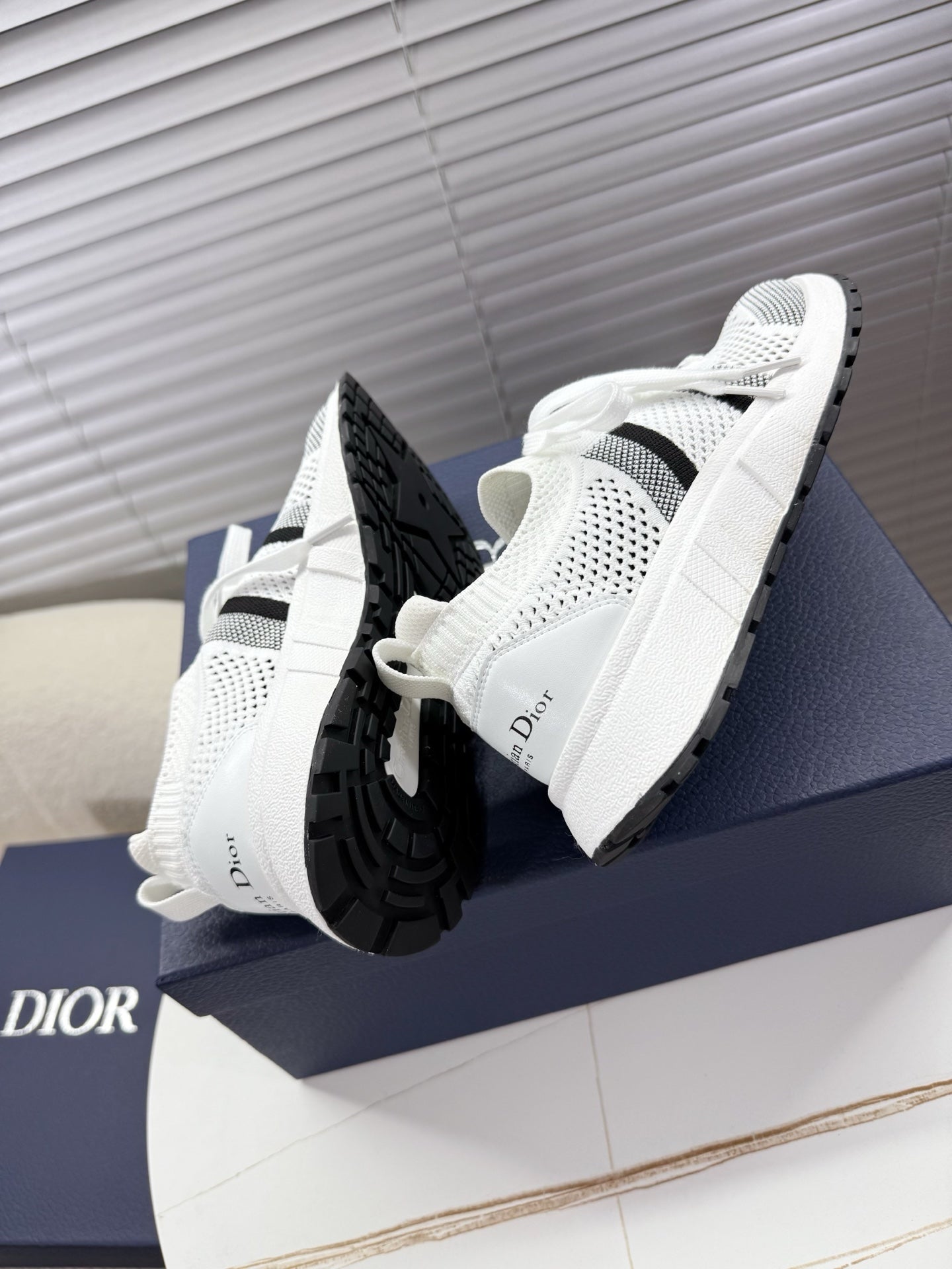 White mesh unisex sneakers with black side details and textured black sole