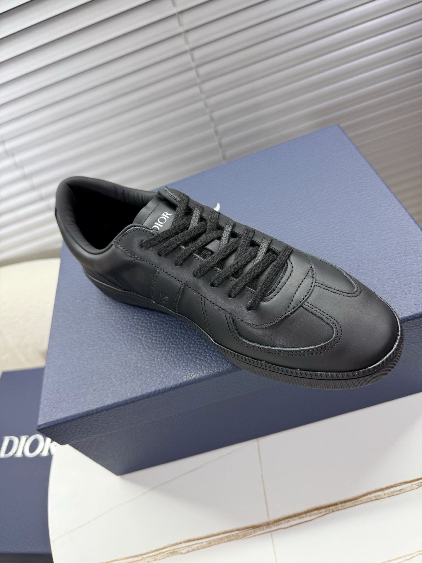 Dior dark leather sneaker with lace-up, side logo and smooth toe panel.