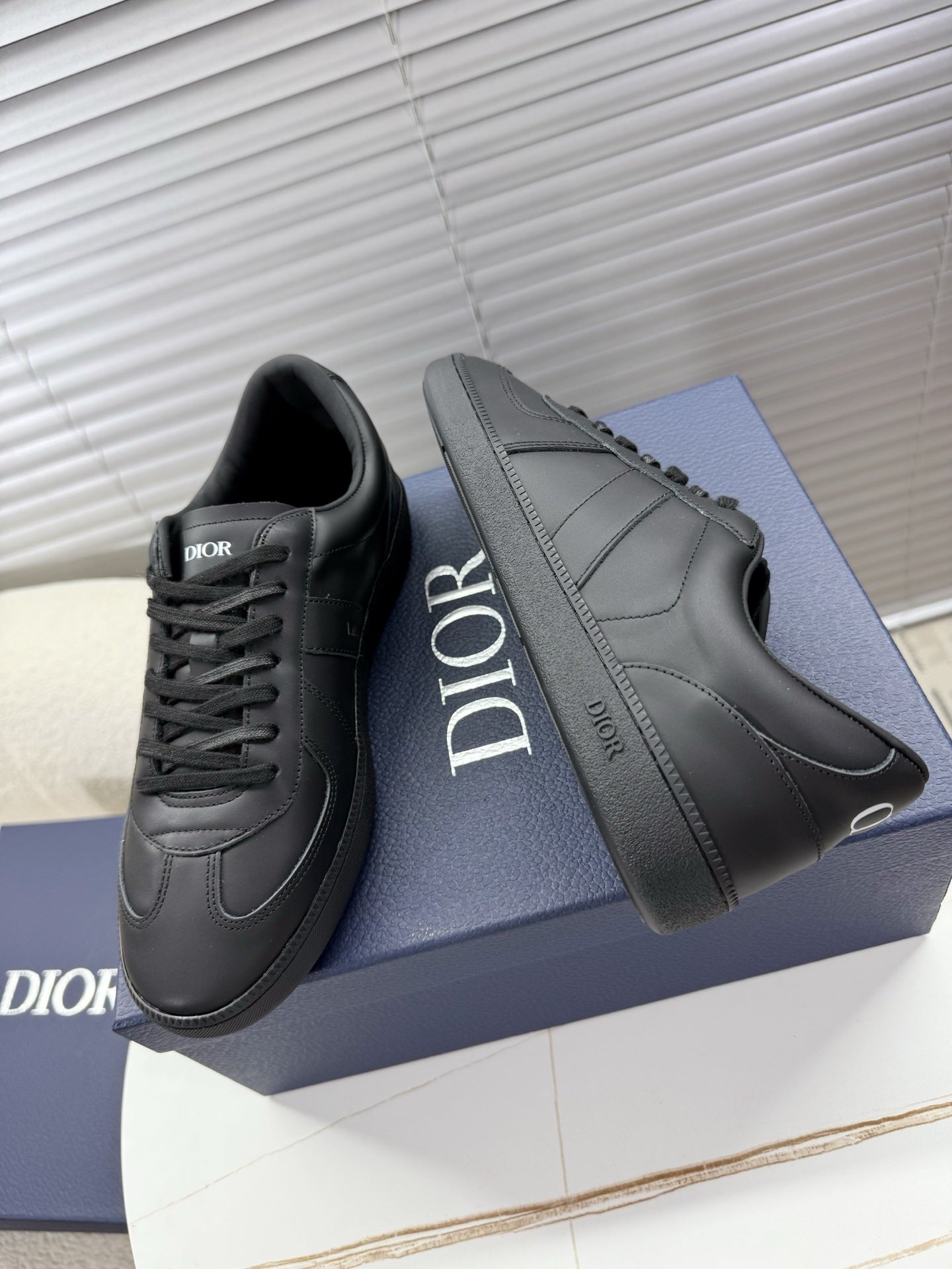 Dior gray leather sneakers with lace-up and bold side logo detailing.