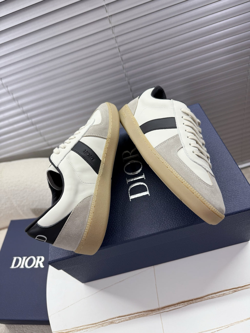 White lace-up sneakers with black panel, cream sole, Dior logo on side