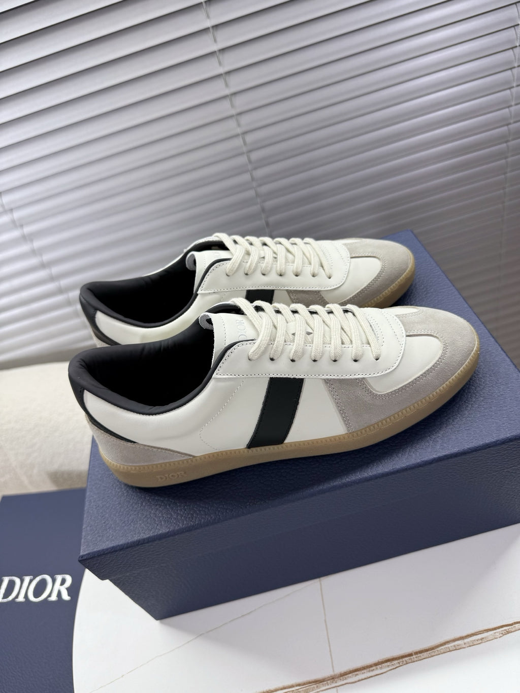 White sneakers with black side stripe and cream sole, lace-up closure, Dior detail