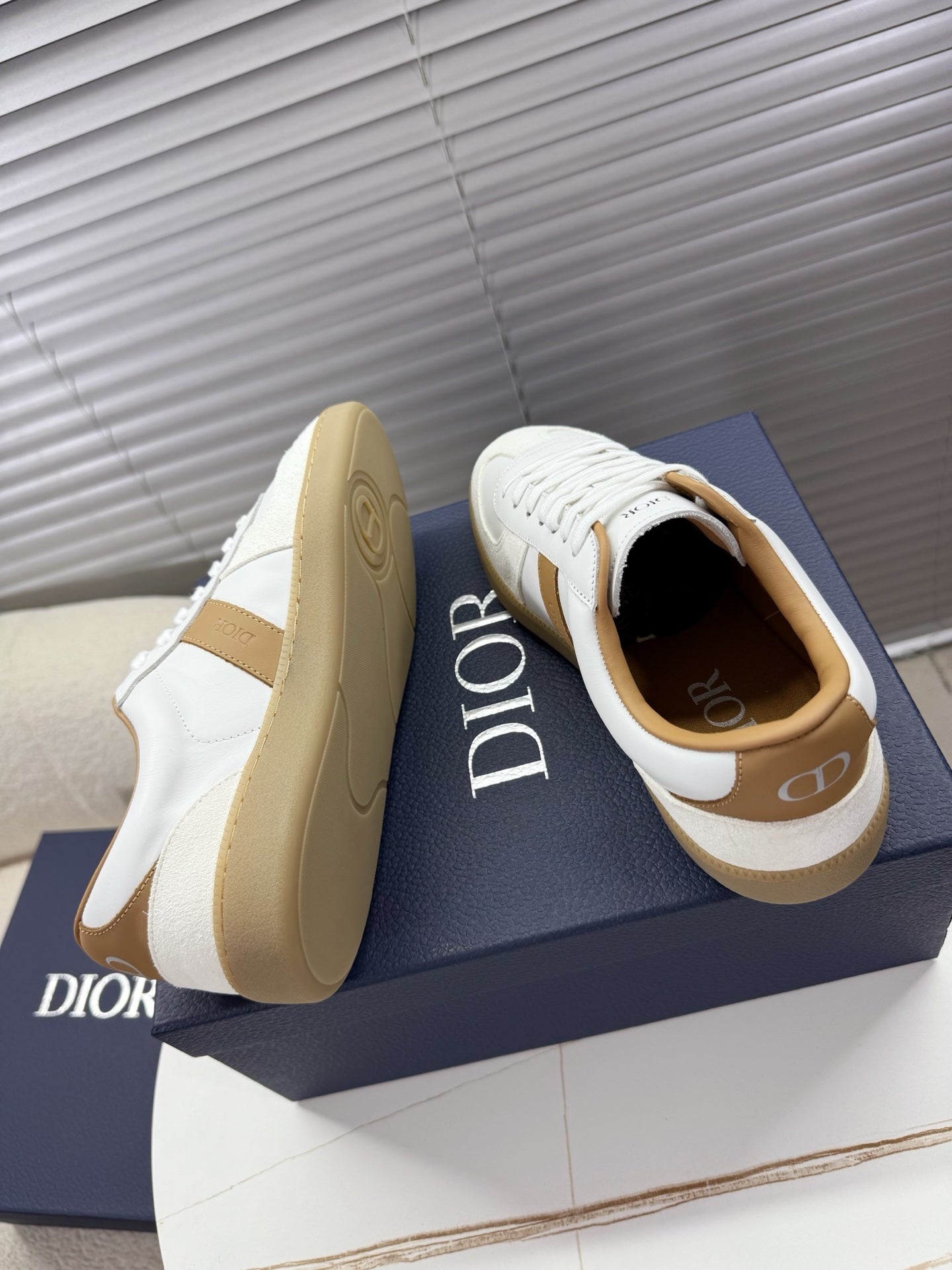 White and tan Dior sneakers with chunky gum-style rubber soles