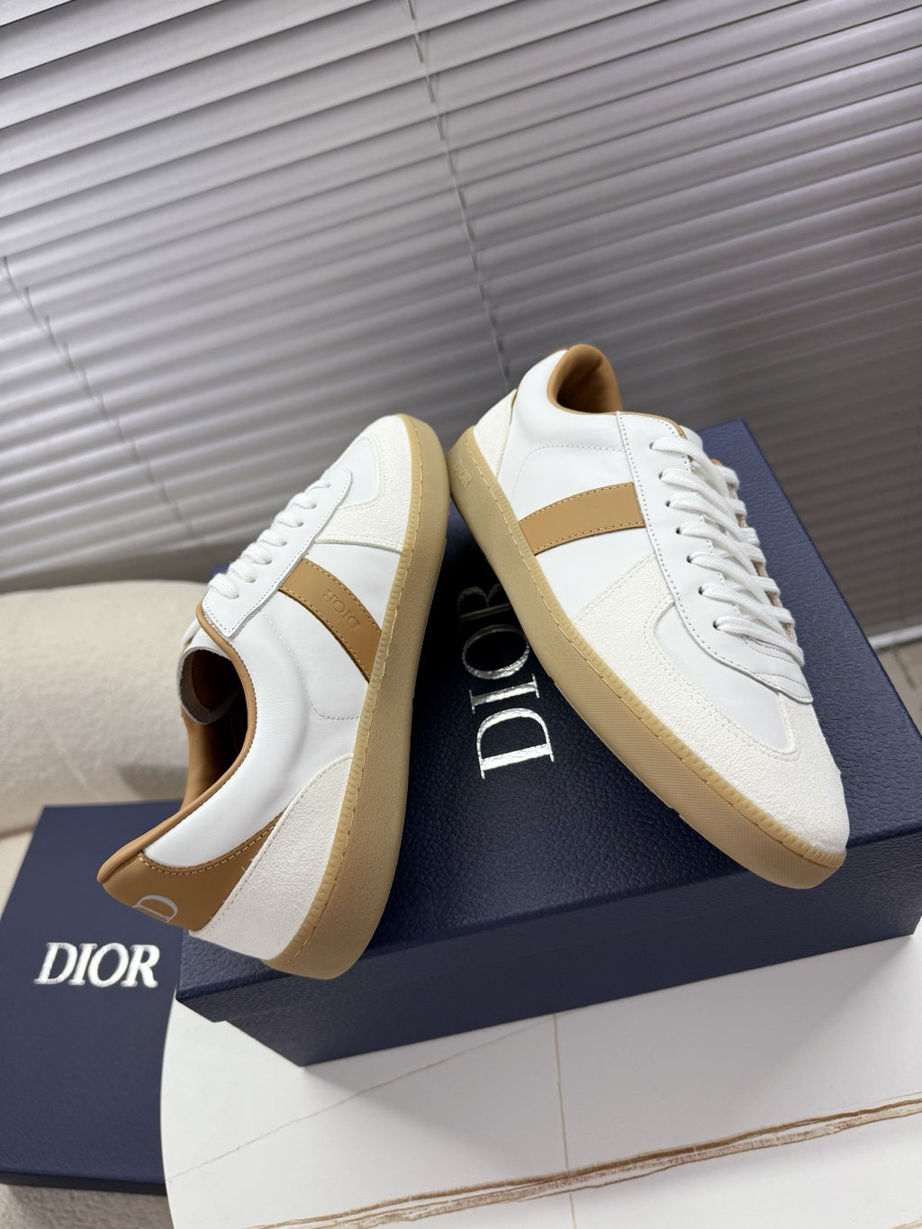 White lace-up sneakers with tan side stripe and padded collar