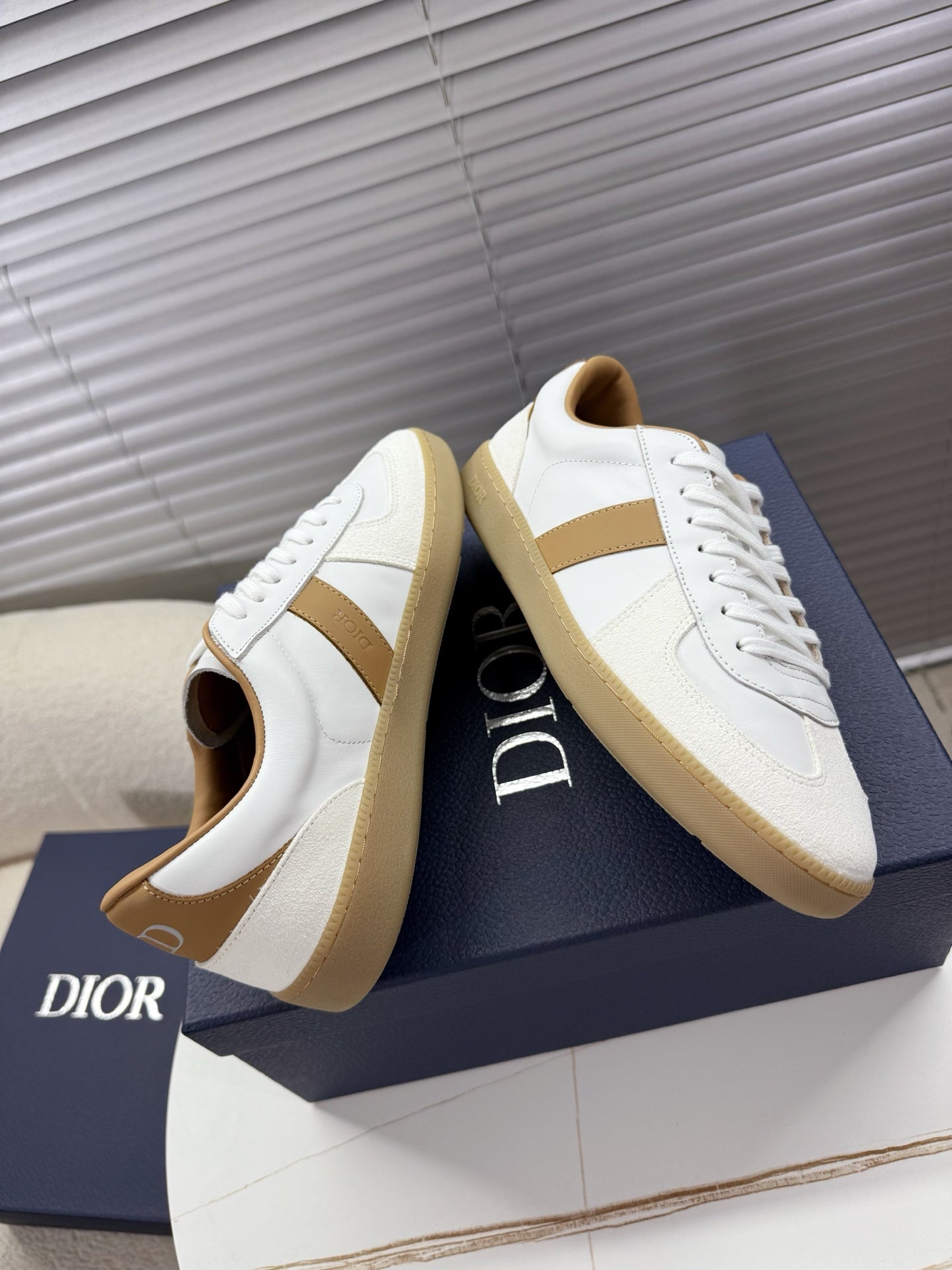 White lace-up sneakers with tan stripe, side view showing low-profile gum sole