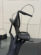 YSL ladies black strappy high-heel sandal held in hand for detail