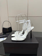 White women’s heeled sandal on display stand, open toe with ankle strap and slim heel