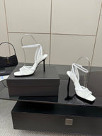 White women’s heeled sandals with open toe, ankle straps, and thin high heels