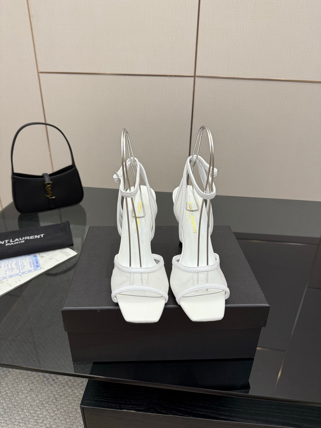 Pair of white women’s heeled sandals with open toe and ankle strap, back view