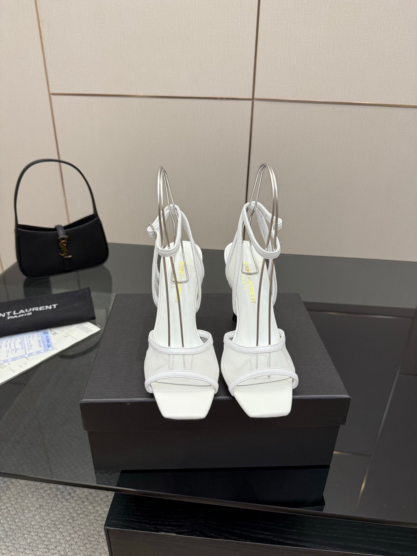 Pair of white women’s heeled sandals with open toe and ankle strap, back view