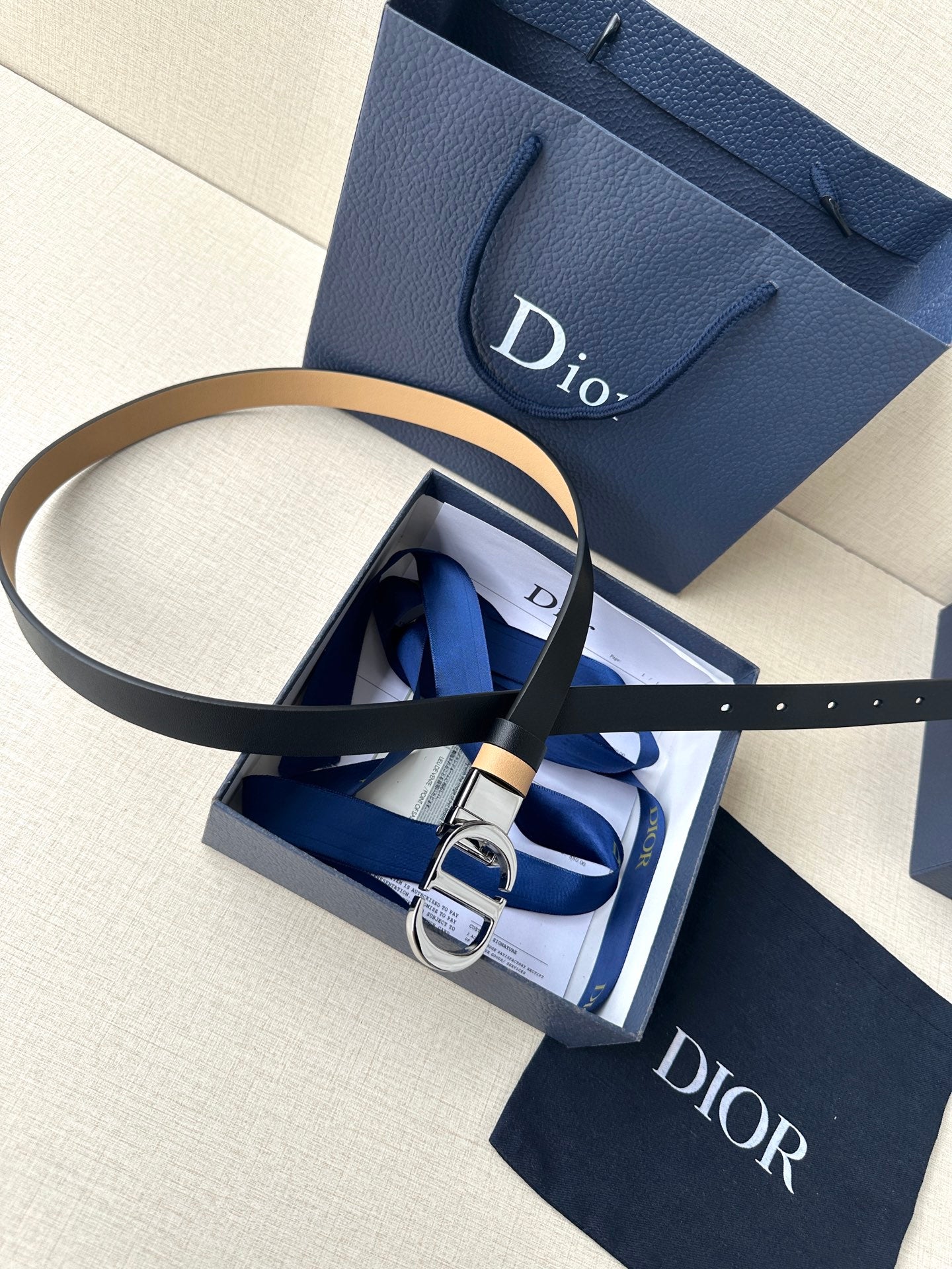 Leather belt with navy strap and tan stripe, with metal buckle detail