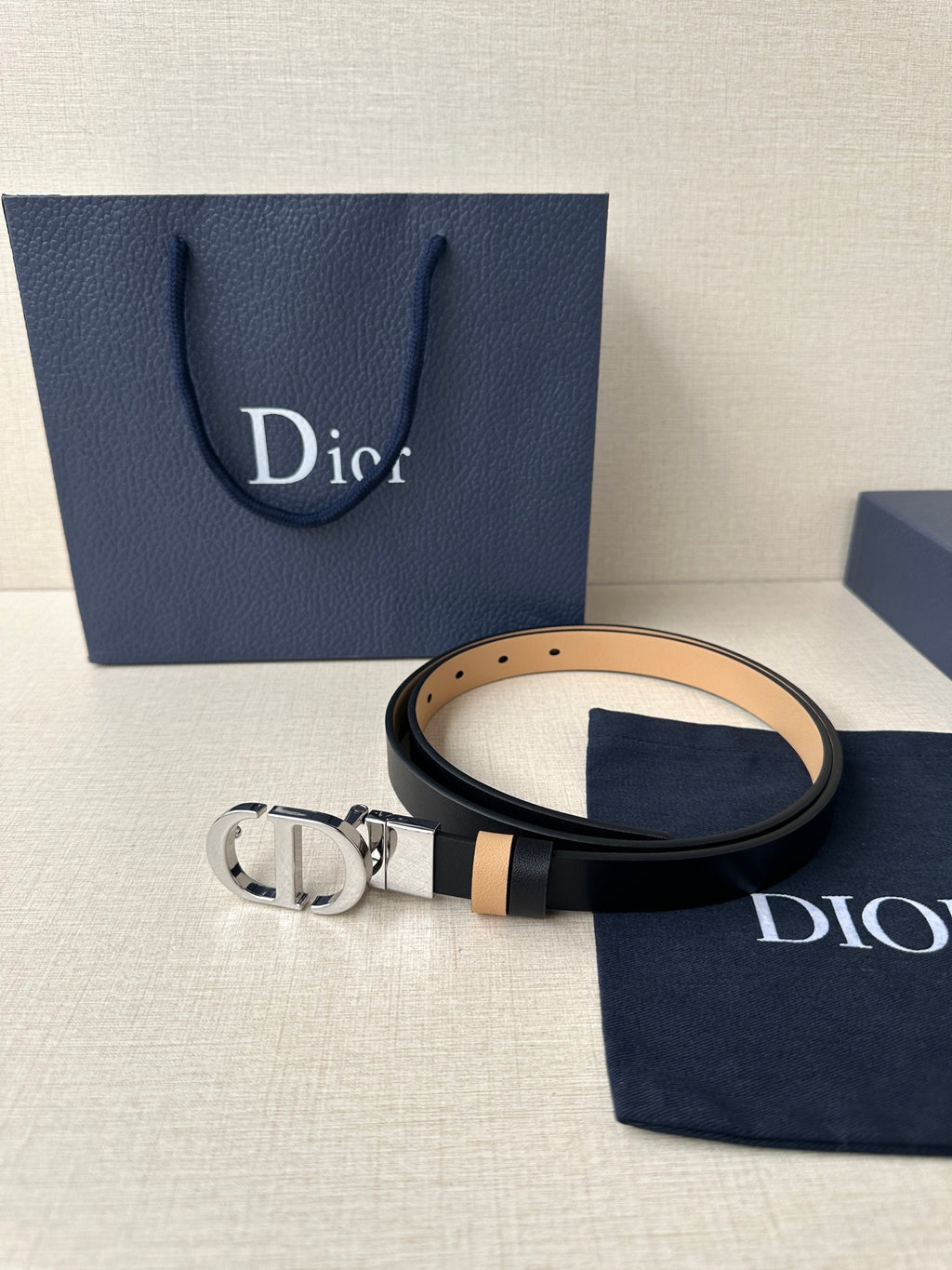 Leather belt with navy strap and tan stripe, featuring a silver-tone buckle