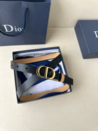 Leather belt with navy strap and gold-tone CD buckle, folded with gift box