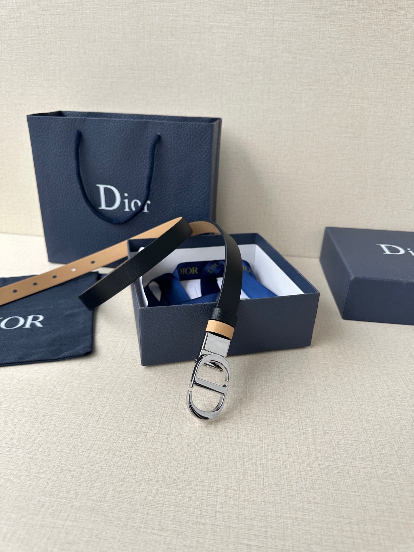 Leather belt with navy strap and tan stripe, metal buckle and strap end