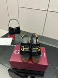 Gucci ladies black heeled sandals with gold-tone buckle straps and wooden platform