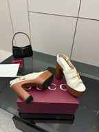White mule sandals with gold buckle detail and chunky brown platform block heel