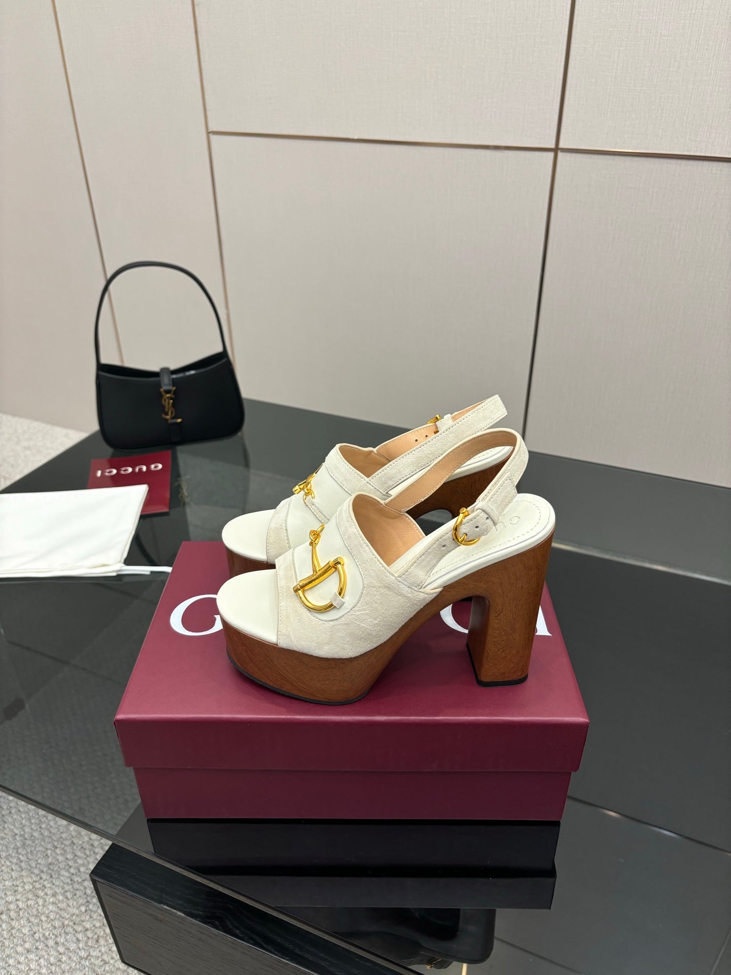 White open-back mule sandals with gold buckle hardware and chunky brown block heel
