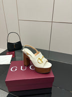 Single white mule sandal with gold buckle detail and chunky brown platform block heel