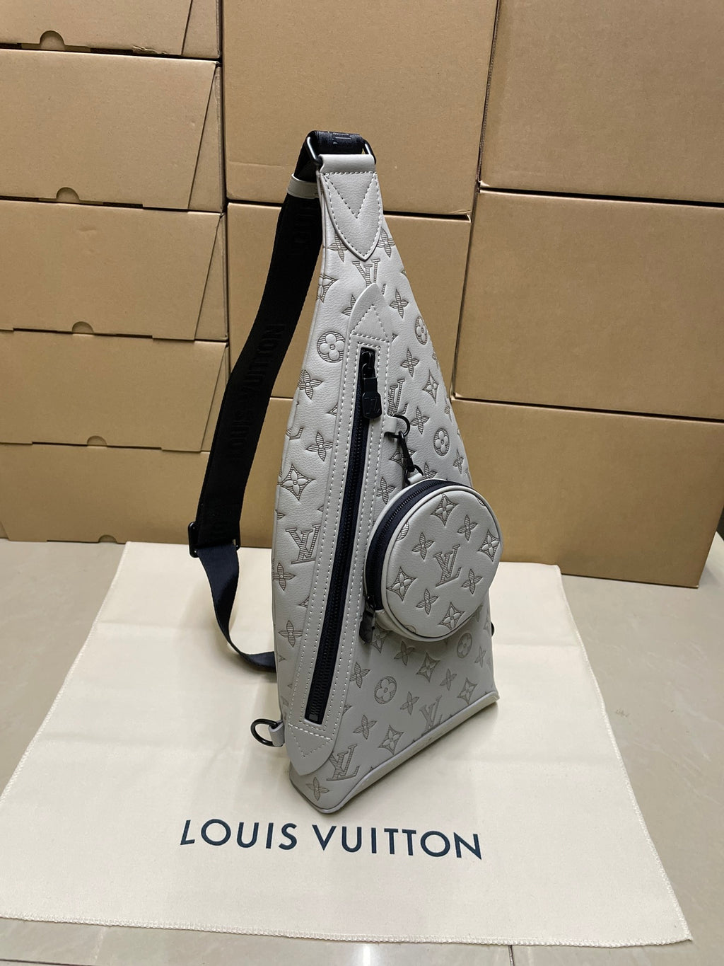 Men's Louis Vuitton monogram sling bag with round zip pouch, light gray/white