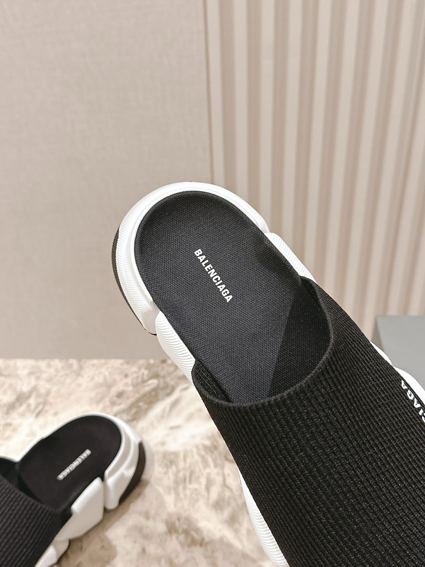 Balenciaga-logo black footbed slide sandal with white edge trim.