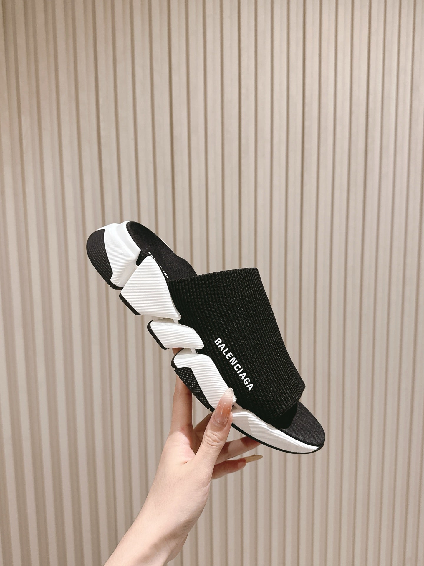 Black knit slide sandals with white midsole and Balenciaga logo strap.