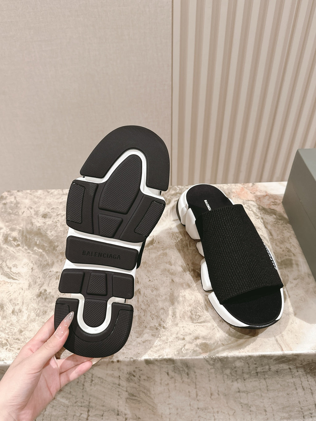 Black slide sandal outsole with Balenciaga logo and white midsole.