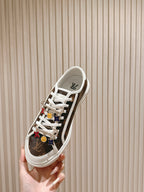 Louis Vuitton low-top sneaker, side profile with white laces and colorful charm details