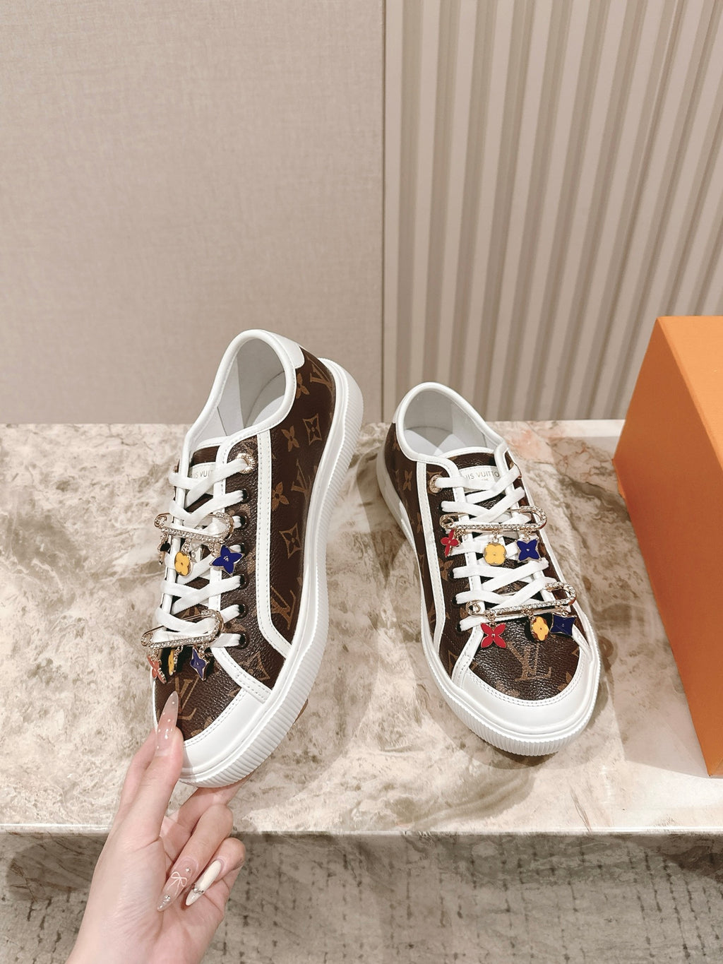 Louis Vuitton low-top sneakers with white laces, brown canvas, side view and colorful motifs