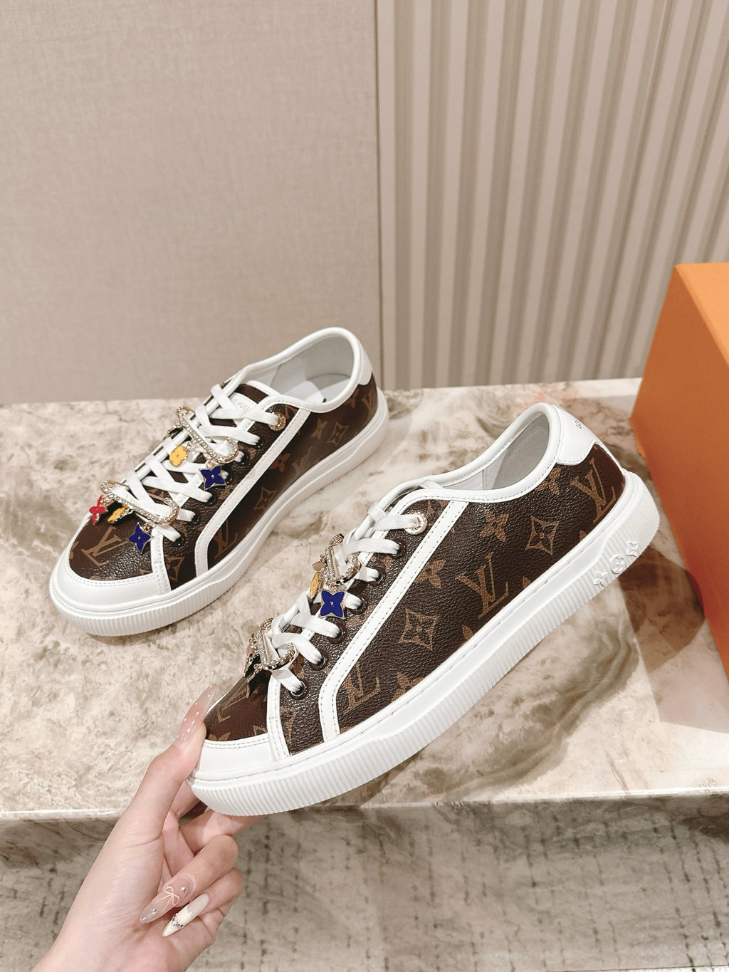 Louis Vuitton low-top sneakers, brown canvas with white laces, front-quarter view