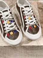Louis Vuitton low-top sneakers, close view of white laces with colorful charm accents
